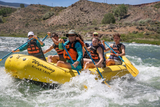 Family Outdoor Activities in Cody Wyoming. Passengers in a raft float down the shoshone through class II rapids with Wyoming River Trips