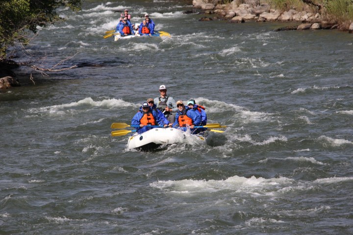 a group of people riding on a raft in a body of water